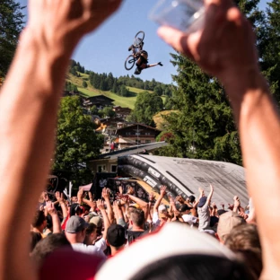 Mountainbiker springt vor begeisterter Menschenmenge in Saalbach Hinterglemm